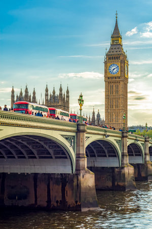 London, UK - 04 May 2024: Double-decker buses on Westminster bridge and Big Ben tower at sunset