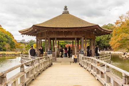 Nara, Japan - November 23, 2024: Ukimido pavilion on Sagi pond in autumnの写真素材