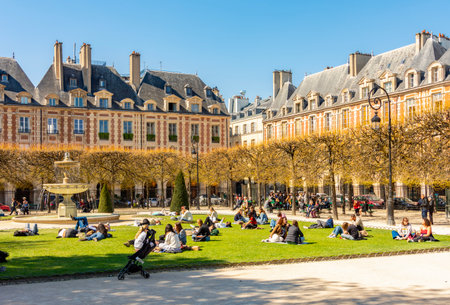 Paris, France - 02 April 2025: People relaxing on Vosges square (Place des Vosges) in Parisの写真素材
