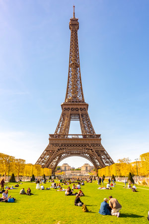 Paris, France - 06 April 2025: People relaxing on Field of Mars at Eiffel tower