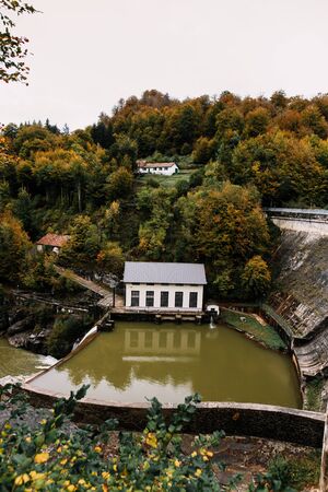 Little house by the river in an autumn forestの写真素材