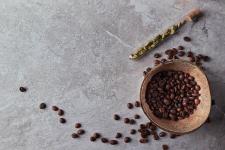 Overhead view of roasted coffee beans in coconut shell on rustic wooden background, Still life photography with roasted coffee beansの写真素材