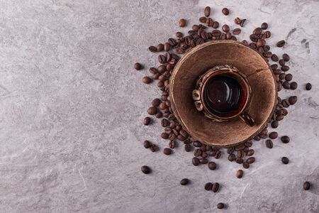 Overhead view of roasted coffee beans in coconut shell on rustic wooden background, Still life photography with roasted coffee beansの写真素材
