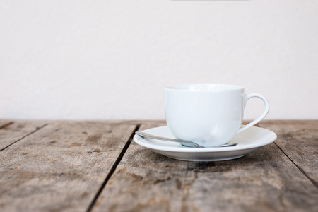 White cup on wood table の写真素材