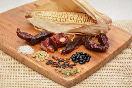 Seeds, spices and chilies on chopping woodの写真素材