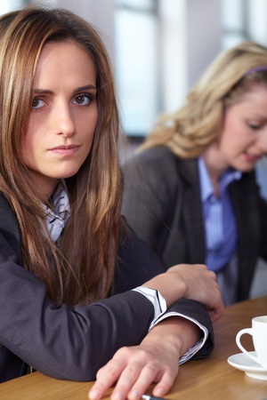 Team of 2 stressed and depressed business people sitting at conference table, negotiation failure or bankrupcy conceptの写真素材