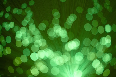 blurred green lights on very dark backgroundの写真素材