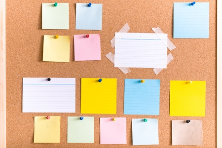 all different types of notes on cork board, blank, stripped, atached with pin and tapeの写真素材