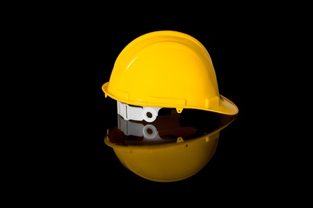 yellow safety hard hat, right hand side shoot, studio shoot isolated on black with reflectionの写真素材