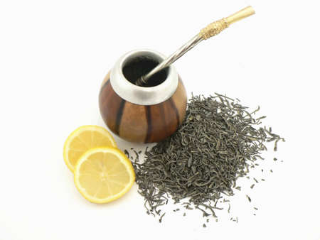 Some japanese green tea leaves closeup and on the background a cupの写真素材