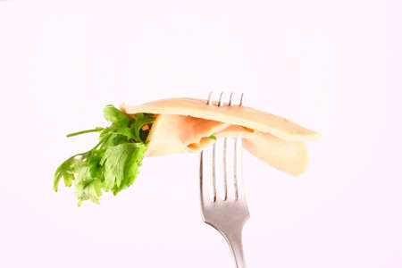 Ham slices on  fork with top slice foldedの写真素材