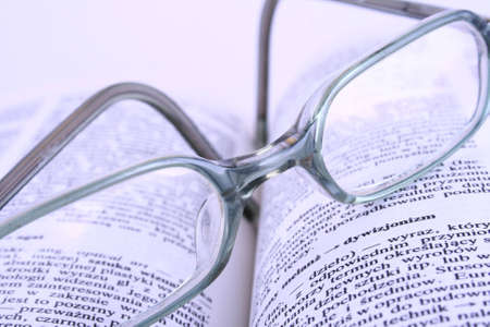 Glasses on opened book books color tonedの写真素材