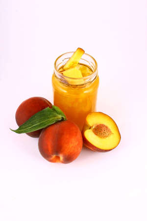 Peach jam on white background in jarの写真素材