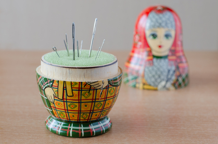 Wooden matryoshka doll-pincushion. Sewing needle.の写真素材