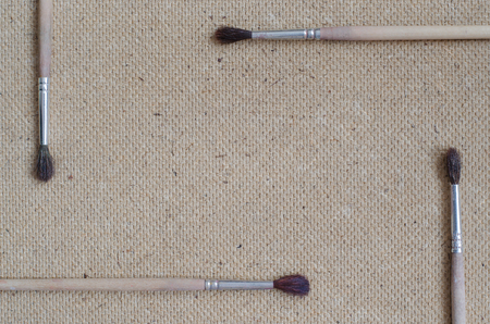 Four paintbrushes. Flat lay. Grey background with space for text