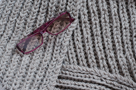 The texture of a knitted woolen fabric. Women's sunglasses. Background