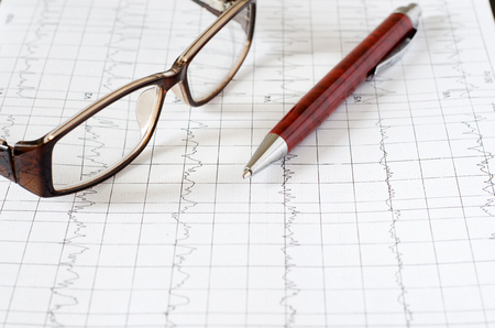 Electrocardiogram graph, heart analysis. Ballpoint pen, glassesの写真素材