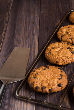 Homemade oatmeal cookies on cooling rack. Wooden background. Side view. Vertical photoの写真素材