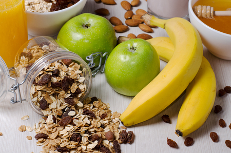 Healthy Breakfast. Granola, apples, bananas, nuts on a white table. Close upの写真素材