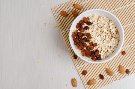 Oatmeal with raisins on the tablecloth from bamboo. Space for textの写真素材