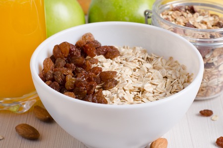 Healthy Breakfast - Oatmeal with raisins. Honey, orange juice, green apples, nutsの写真素材