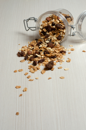 Oatmeal with nuts and raisins. Scattered on the white tableの写真素材