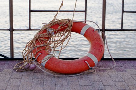 Orange lifebuoy with rope on the pier. The background - seaの写真素材