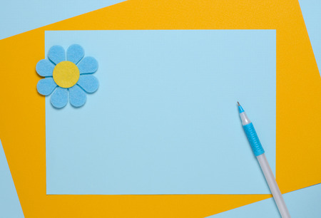 Blue flower made of felt on a blue and orange background. Greeting card. Space for textの写真素材