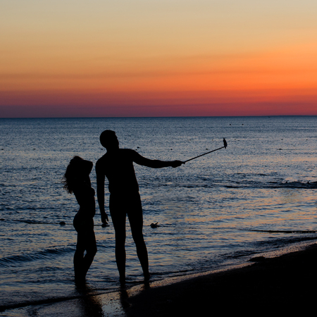 Anapa, RUSSIA - August 01, 2017. A girl and a boy are photographed on the beach. Selfie. Evening, dusk, sunset.のeditorial素材