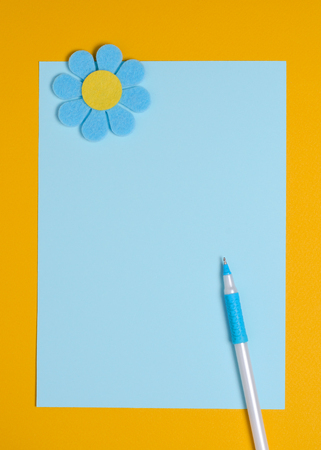 Blue flower made of felt on a blue and orange background. Greeting card. Space for textの写真素材