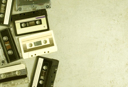 A lot of old audio cassettes. Gray old background. Vintage toned and retro color stylized. Space for text. Flat top vievの写真素材