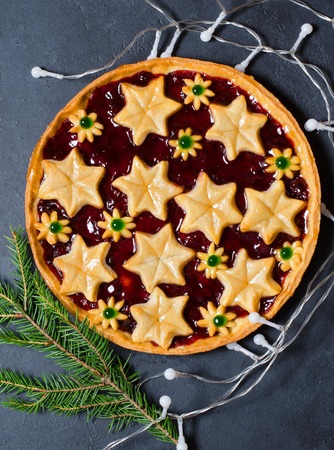 Christmas home sweet cake with jam on dark background. Green branches of a Christmas tree. Vertical photoの写真素材