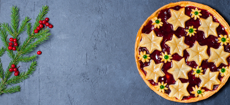 Christmas home sweet cake with jam on dark background. Green branches of a Christmas tree. Copy space. Flat layの写真素材