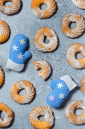 Christmas cookie pattern on grey background. Two blue winter gloves. Flat Layの写真素材