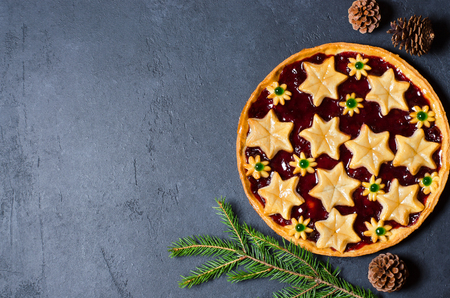 Christmas home sweet cake with jam on dark background. Green branches of a Christmas tree. Copy space. Flat layの写真素材