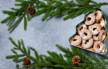Christmas cookies in a box in the form of a Christmas tree. Green branches with pine cones. Flat Lay. Copy spaceの写真素材