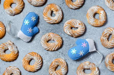 Christmas cookie pattern on grey background. Two blue winter gloves. Flat Layの写真素材