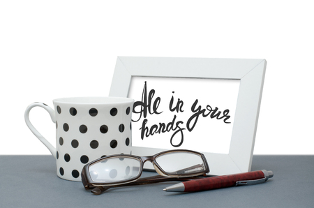 All in your hands. Handwritten inscription in the frame. Coffee Cup, glasses, pen. Close-upの写真素材