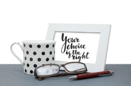 Your choice is the right. Handwritten inscription in the frame. Coffee Cup, glasses, pen. Close-upの写真素材