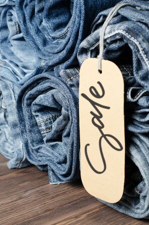 Denim. Lots of blue jeans rolled up. Sale - handwritten inscription on a paper labelの写真素材