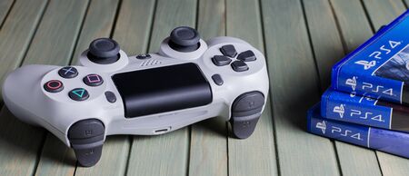 IZHEVSK, RUSSIA - 17 OCTOBER, 2019: White joystick game console PlayStation. Multiple PS4 games....
