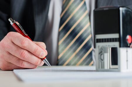 A notary or a lawyer signs the document. A fountain pen in a man's hand