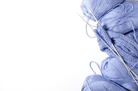 Balls of blue yarn and knitting needles. White background. Copy space. The concept of women 's...