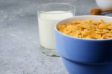 Corn flakes in a plate and milk in a glass. Healthy breakfast. Copy space.の写真素材