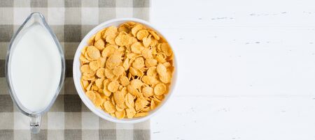 Corn flakes and milk on the tablecloth. Healthy and nutritious Breakfast. White background. Copy...