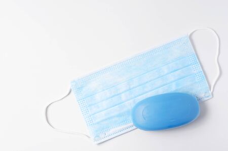 Disposable medical mask and soap on a white background. Concept protection from the virus during an epidemic of disease. Copy spaceの写真素材