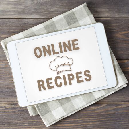 Online recipes. App in smartphone. Brown wooden background.