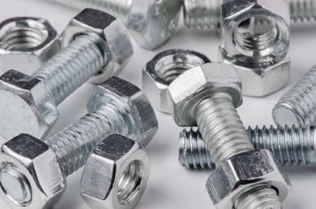 Lots of metal bolts and nuts. Tool for fixing. White background