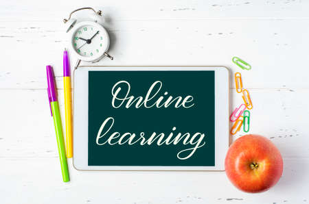 Online learning - handwritten inscription on a tablet. The concept of distance training for...