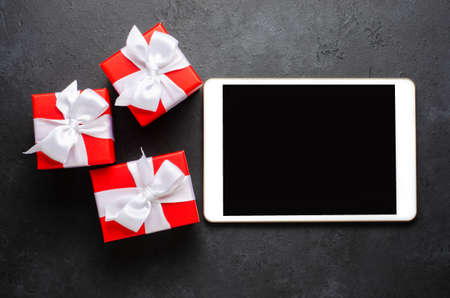 Red gift boxes and a tablet with a blank screen for text. Copy spaceの写真素材